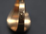 a close up of a gold ring on a black surface
