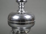 a silver lamp with a white glass shade on top of it