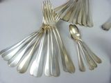 silver spoons and spoon spoons sitting on a white table