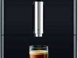 the jura coffee machine has a glass of coffee in front of it