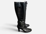 black leather boots with buckles on the side of them