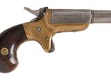 un vieux revolver avec un manche en bois sur fond blanc