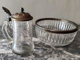 un pichet en verre et un saladier posés sur une table en marbre