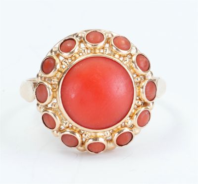 an image of a coral and gold ring on a white background