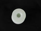 a white cup with a green lid on a black table