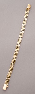 a close up of a gold bracelet on a gray surface