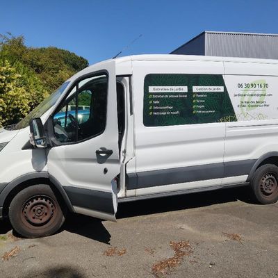 La camionnette blanche est garée sur le parking, la portière ouverte.