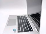 a silver laptop with a black keyboard on a white surface