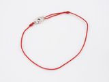 a red string bracelet with an evil eye charm on a white background