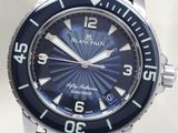 a close up of a wrist watch with a blue dial