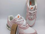 a pair of pink and white sneakers with a tag on them