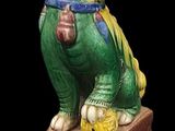 a statue of a green dog sitting on top of a box