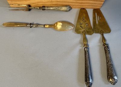 un couteau, une fourchette, une cuillère et un repose-couteau posés sur une table