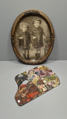 une photo de deux enfants debout à côté d'une palette de peinture