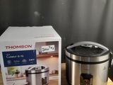 une boîte de nourriture posée sur une table à côté d'un cuiseur à riz