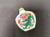 un gros plan d'un petit vase blanc et vert orné d'un dragon
