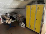 a yellow locker in the corner of a room next to a table