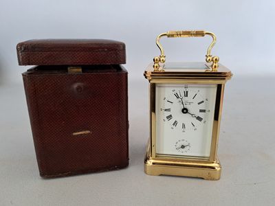 a small clock sitting next to a box on a table