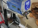 a picture of a man using a power washer in a garage