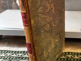 an old book sitting on top of a rug next to a glass case