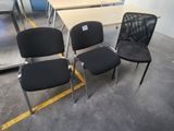 three black chairs sitting next to each other in a room