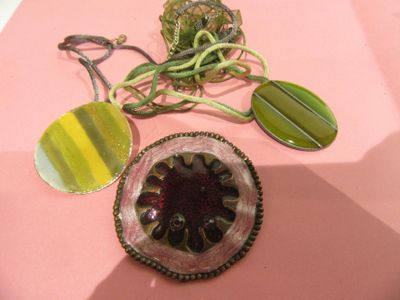 a pink table topped with a glass bowl and a pair of earrings