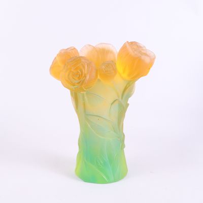 un vase contenant des fleurs, posé sur une surface blanche