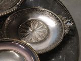many silver dishes sitting on top of a table