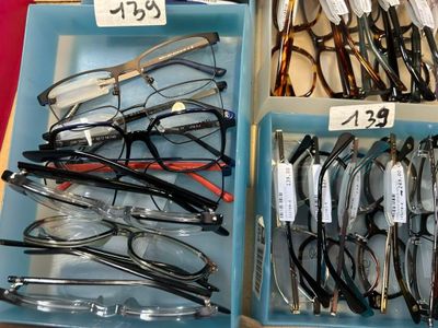 many pairs of glasses sitting in a blue box