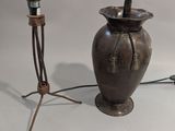 une lampe posée à côté d'un vase sur une table