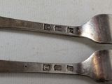 two spoons that are sitting on a table