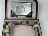 une personne tenant une valise dans laquelle se trouvent une brosse et un miroir