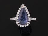 a blue sapphire and diamond ring on a black surface