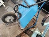 a blue wheelbarrowr sitting on a pallet in a warehouse