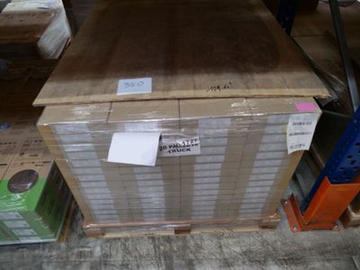 une boîte portant une étiquette, posée sur une palette dans un entrepôt