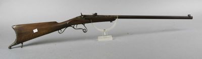 a rifle with a wooden barrel on a stand on a white surface