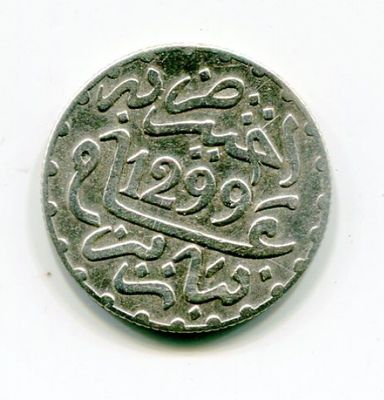 an old silver coin with arabic writing on it on a white surface