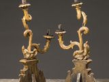 a pair of carved wood candlesticks with figures on them