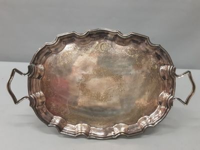 an antique silver plate with handles and handles on a table