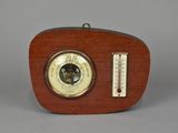 an old fashioned wooden clock with a thermometer on top of it