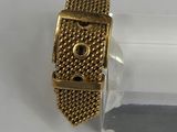 an image of a close up of a gold bracelet on a white surface