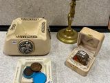 a small box with a coin inside of it next to other items