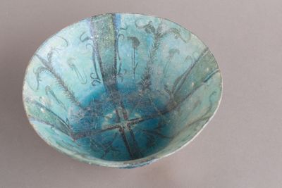 un bol bleu posé sur une table blanche