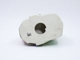 a small white object with a hole in it on a white surface