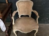 an old chair is sitting in front of a table and a chair