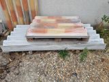 a pile of wood sitting on the ground next to a building