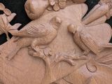 two birds sitting on a tree branch carved into a wall