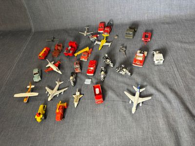 beaucoup de petits avions et de petits camions en jouet posés sur une surface grise