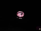 un diamant rose sur une surface noire