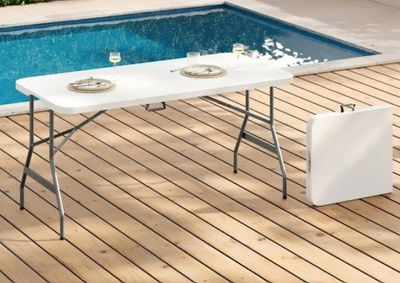 une table installée sur une terrasse en bois près d'une piscine